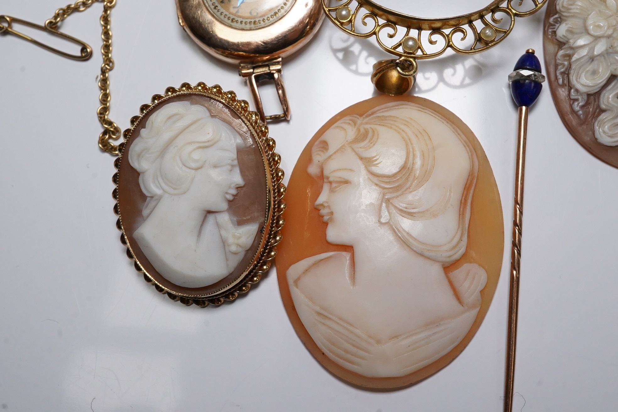 Three carved oval cameo shells, including tow in 9ct pendant or brooch mount, a 9ct gold wrist watch (a.f.) and a stick pin. Condition - poor to fair